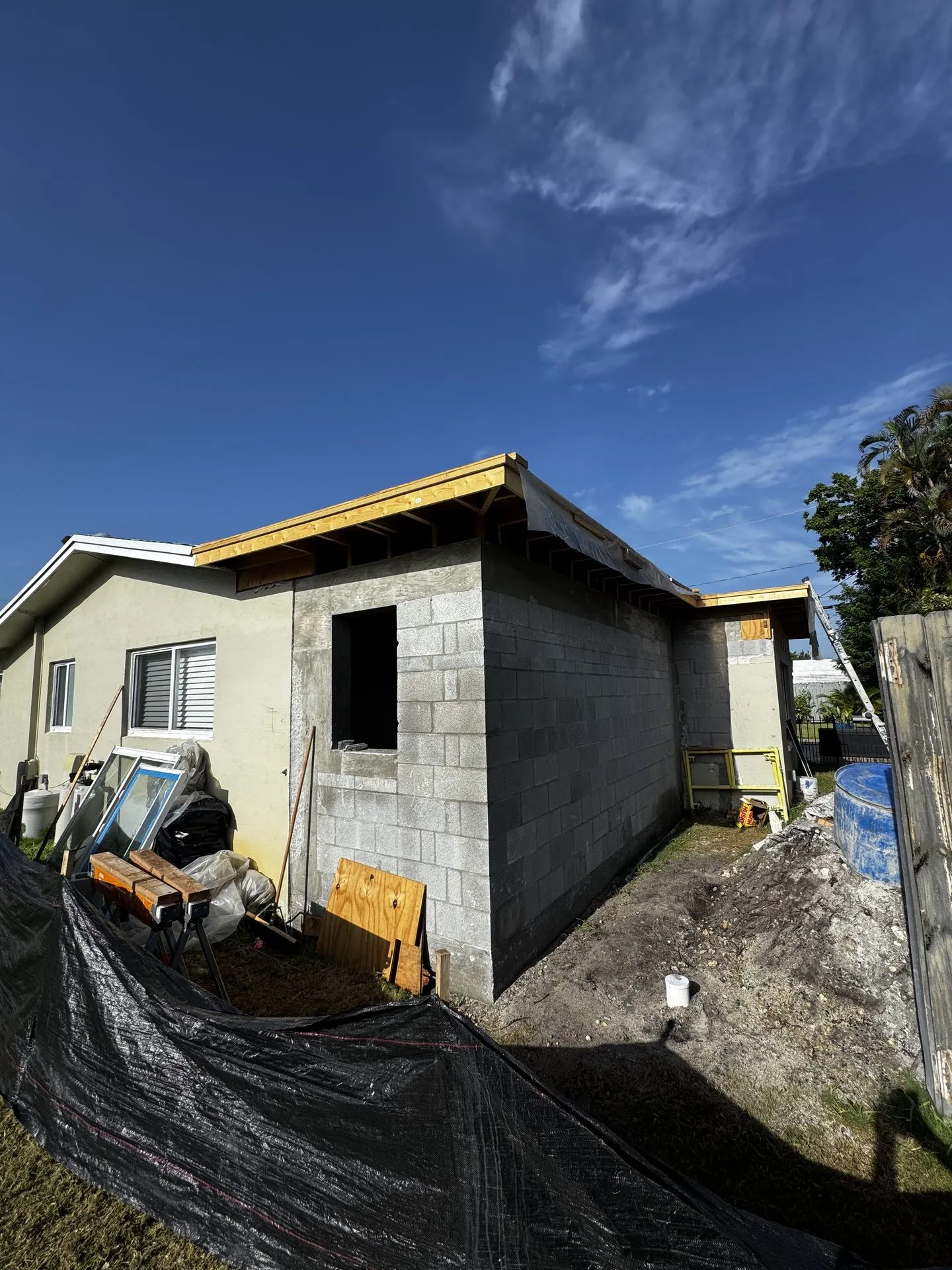 Block addition with roof framing under construction on an existing home
