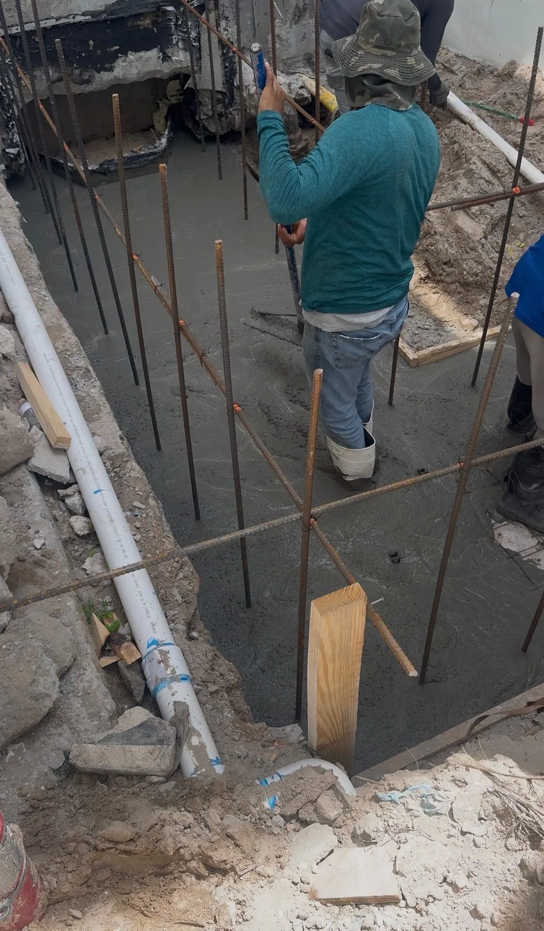 Crew pouring concrete into a reinforced footing