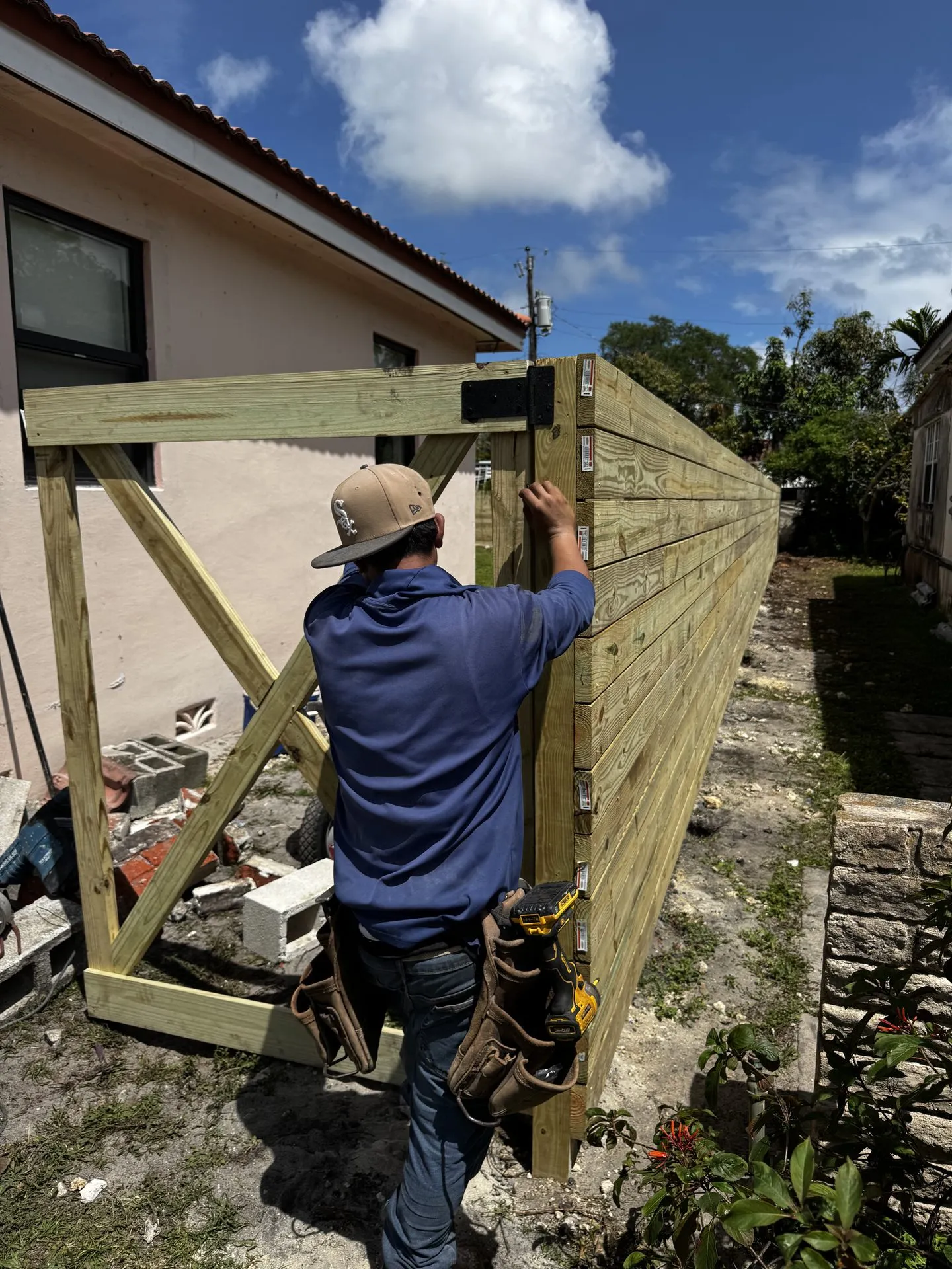 Contractor installing the wood frame for a backyard fence and gate