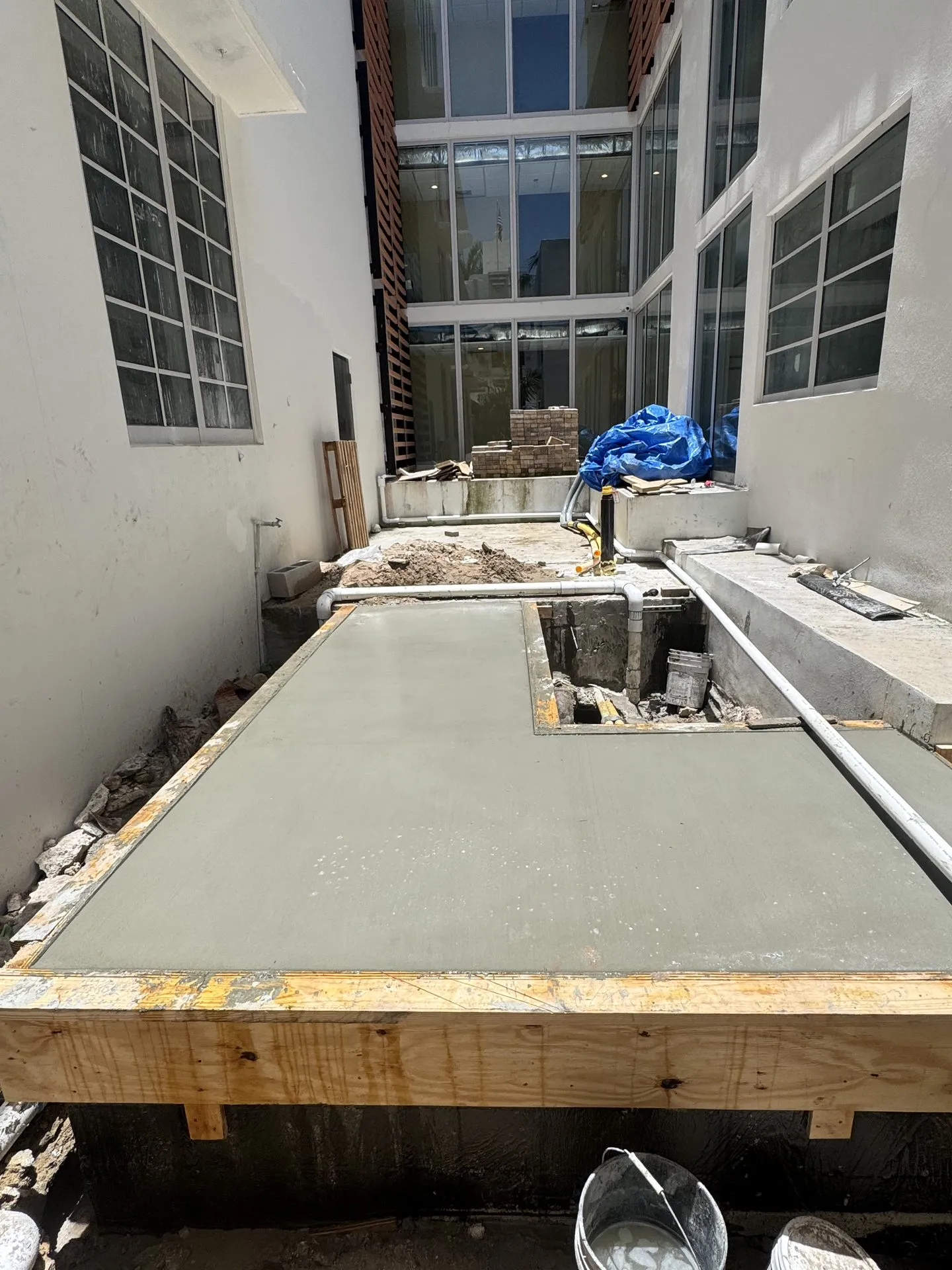 Freshly poured and leveled concrete slab inside wood forms at a Miami property