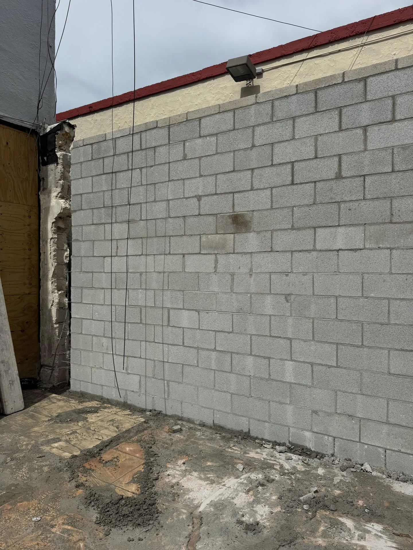 Gray concrete block wall built against an existing building